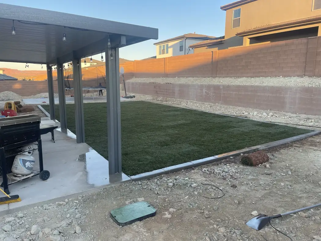 Completed backyard with freshly installed sod and landscape curbing